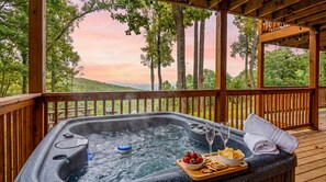 A hot tub with a wooden deck, surrounded by trees and a scenic view. - Heavenly Heights by Ghosal Luxury Lodging (Sevierville)