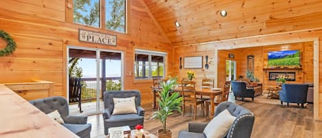 L’intérieur d’un chalet en bois comprend un coin repas, des sièges et une cheminée.