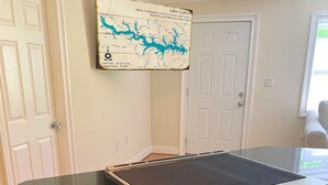 Une cuisine équipée d’une cuisinière en acier inoxydable, de meubles en bois et d’une carte accrochée au mur.
