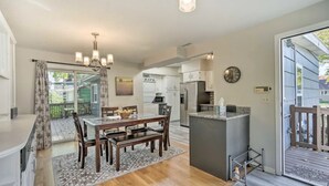 A modern kitchen with a dining area, wooden flooring, and a chandelier. - Your TwinCities Memorable Stay (Saint Paul)
