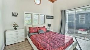 A bedroom with a large bed, a window, a white dresser, and a small potted plant. - Your TwinCities Memorable Stay (Saint Paul)