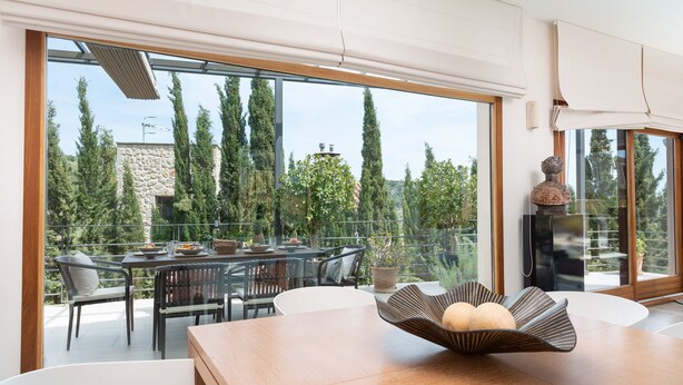 Uma área de refeições moderna com uma mesa grande, cadeiras e uma tigela decorativa.