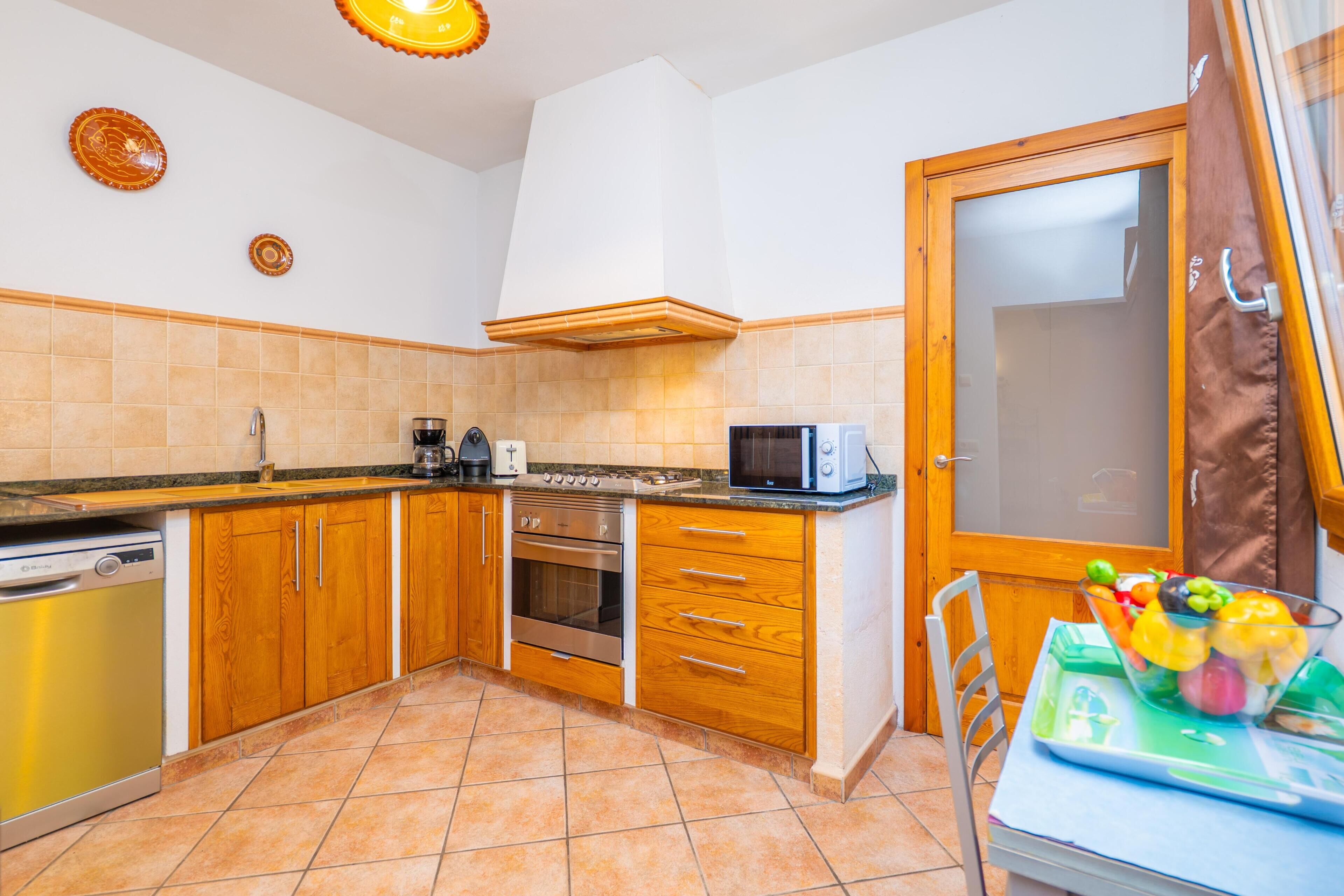 A kitchen with wooden cabinets, a microwave, a stove, and a dishwasher.