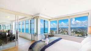 A modern hotel room with a large bed, a glass door leading to a balcony, and a city view. - Sub Penthouse 6203 - 3 bedrooms Level 62 (Gold Coast)