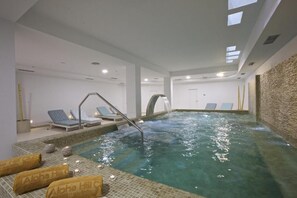 A spa area with a hot tub, lounge chairs, and towels.