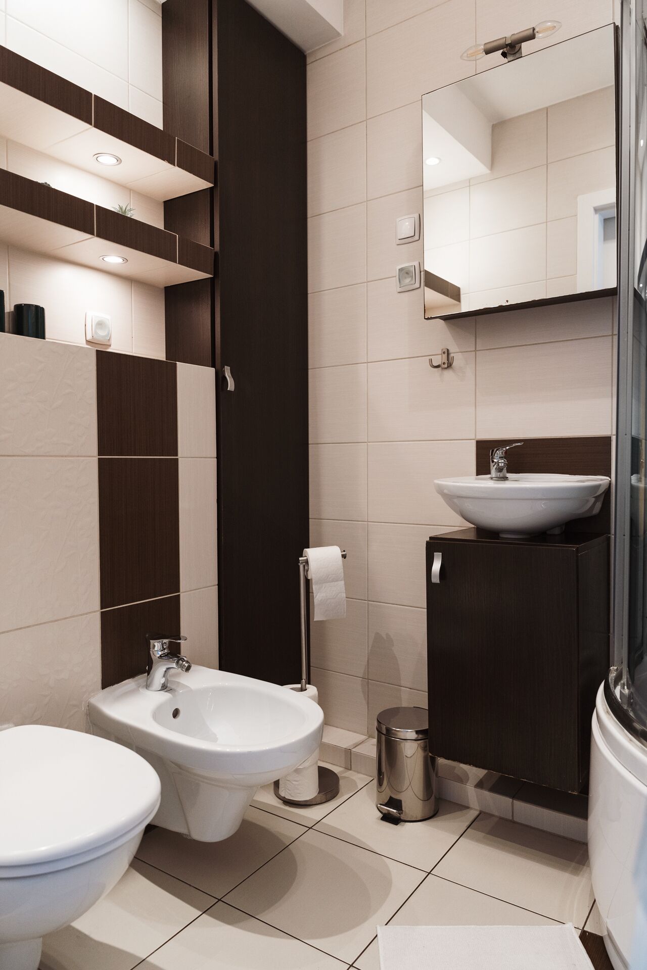 A modern bathroom with a bidet, a sink, and a toilet.