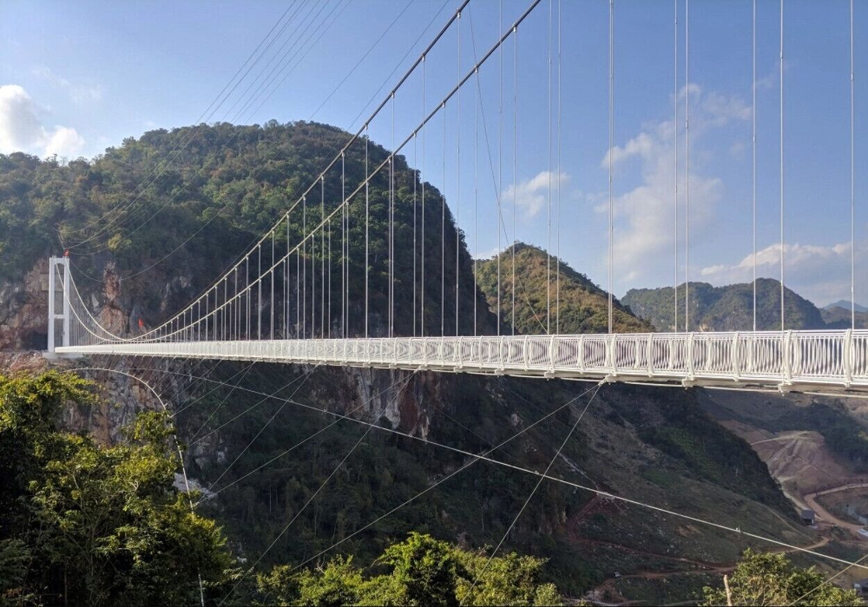 A suspension bridge spanning a deep gorge with steep cliffs on either side.