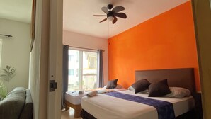 Un dormitorio con dos camas, un ventilador de techo y vistas al exterior.
