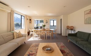 Ein Wohnzimmer mit einer Couch, einem Couchtisch und einem Essbereich mit Stühlen und einem Tisch.