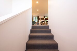 Eine Treppe führt zu einem Essbereich mit Stühlen und einem Tisch.