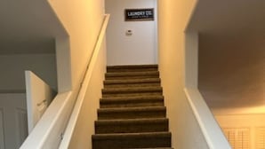A carpeted staircase with a sign reading "Laundry Co."