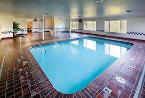 Ein Hallenbad mit Fliesenboden und blauen Wasser.