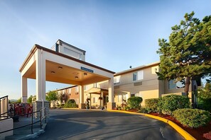 A hotel entrance with a covered parking area, a sign indicating the name and address, and a well-maintained landscaped garden. - Epic Vacay! King Unit, Breakfast, Spa & Wellness Center, Close to Attractions (Sequim)