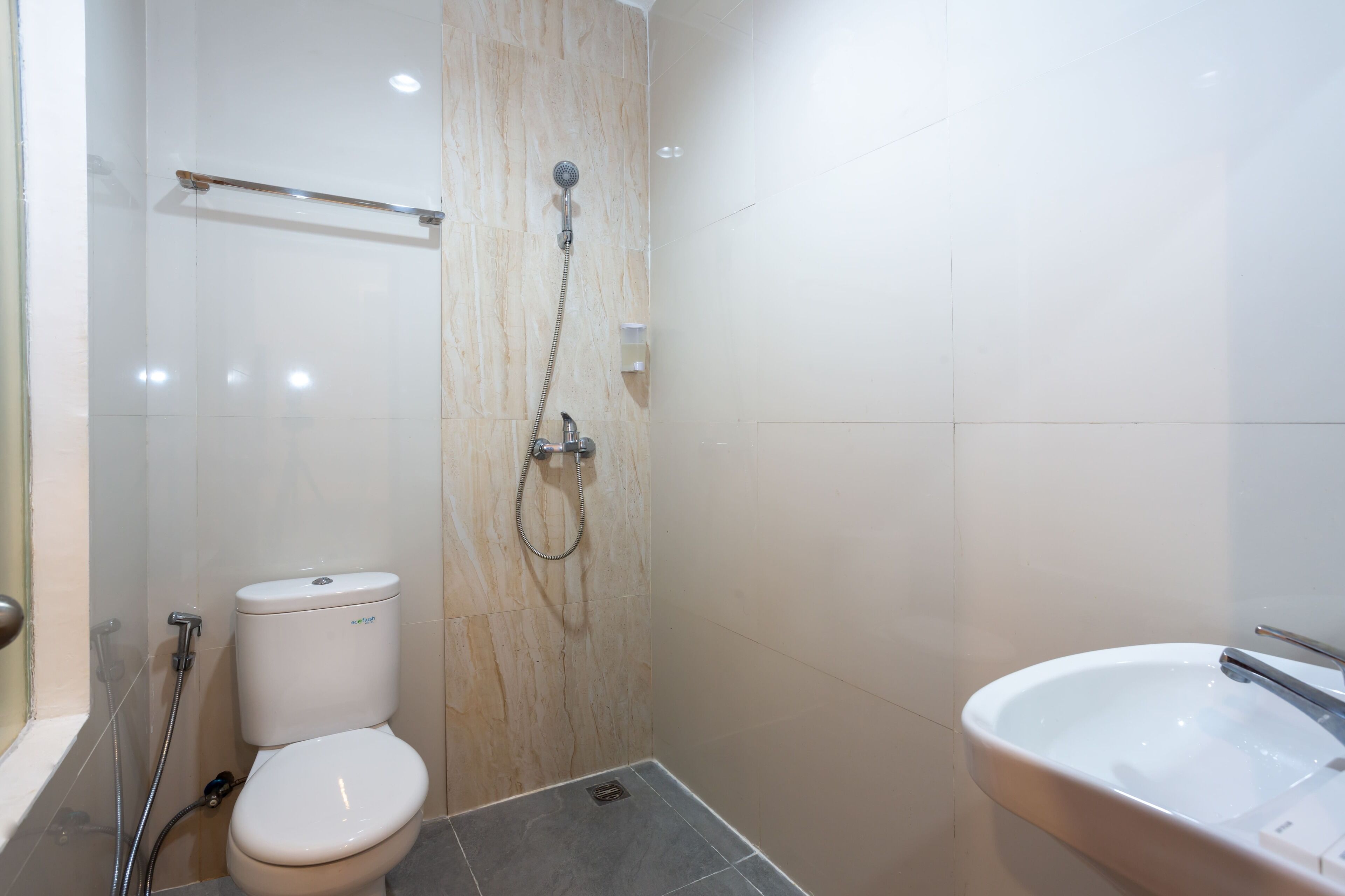 A bathroom with a toilet, shower, and sink.