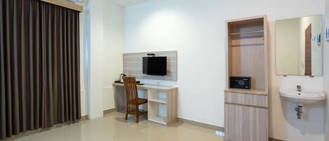 A modern room with a desk, chair, TV, wardrobe, and sink.