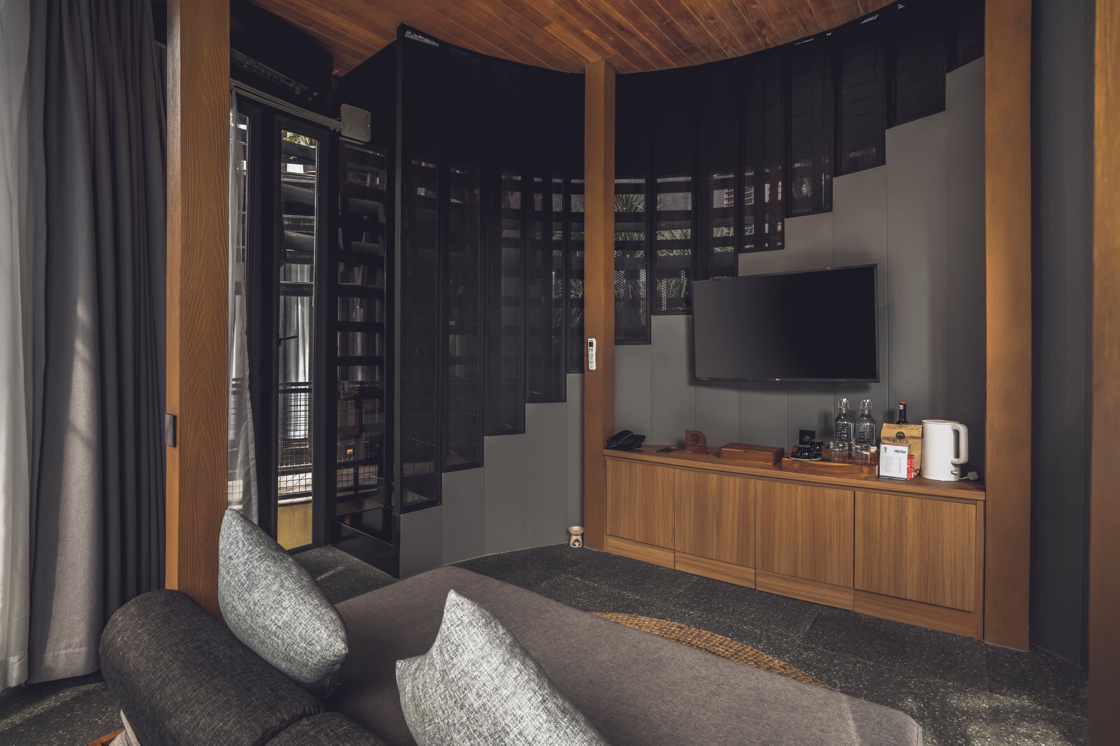 Ein modernes Wohnzimmer mit einer Couch, einer Kaffeemaschine, einem Fernseher und einem Bücherregal.