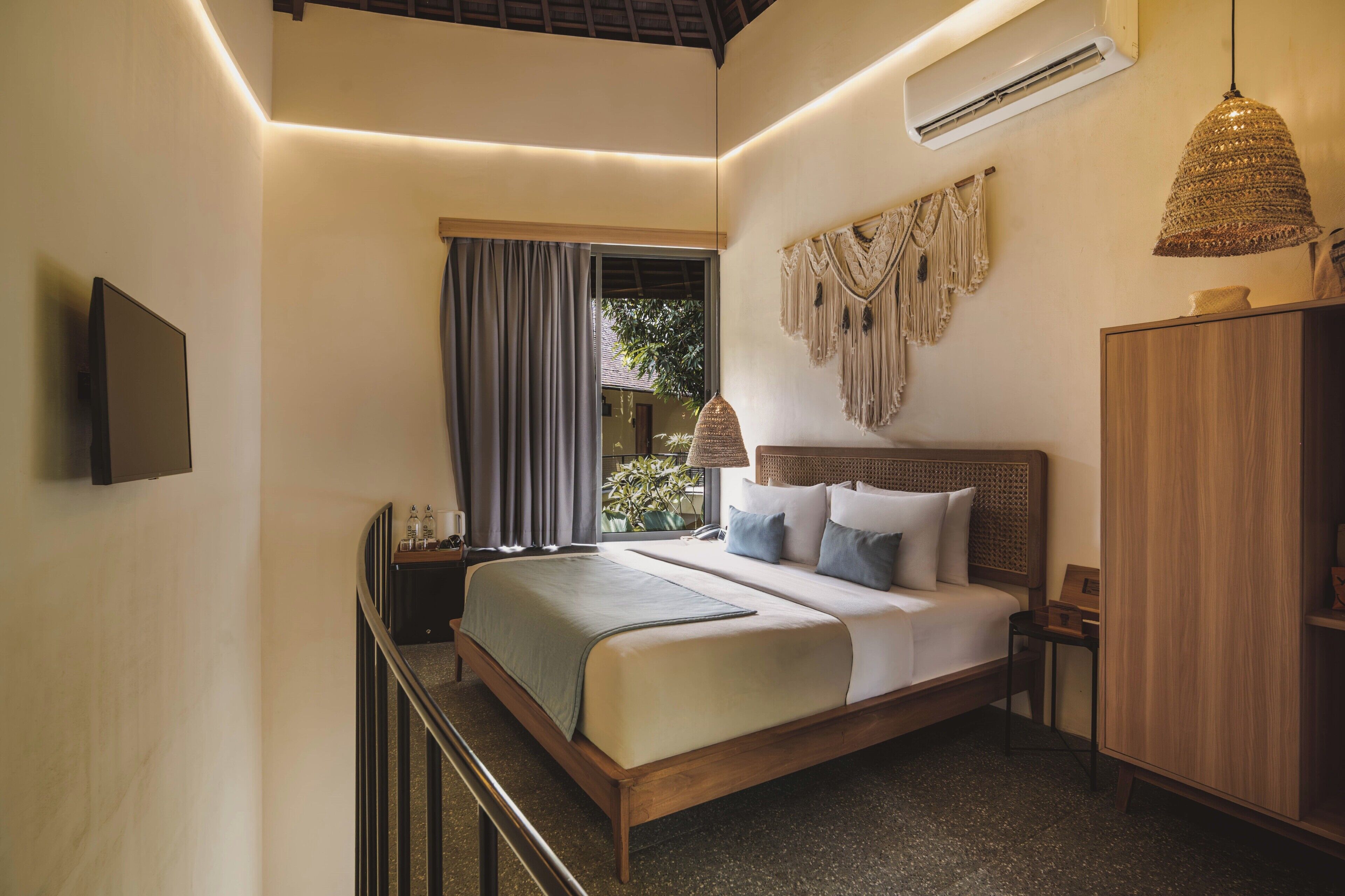 Een slaapkamer met een bed, nachtkastje, lamp en garderobe.
