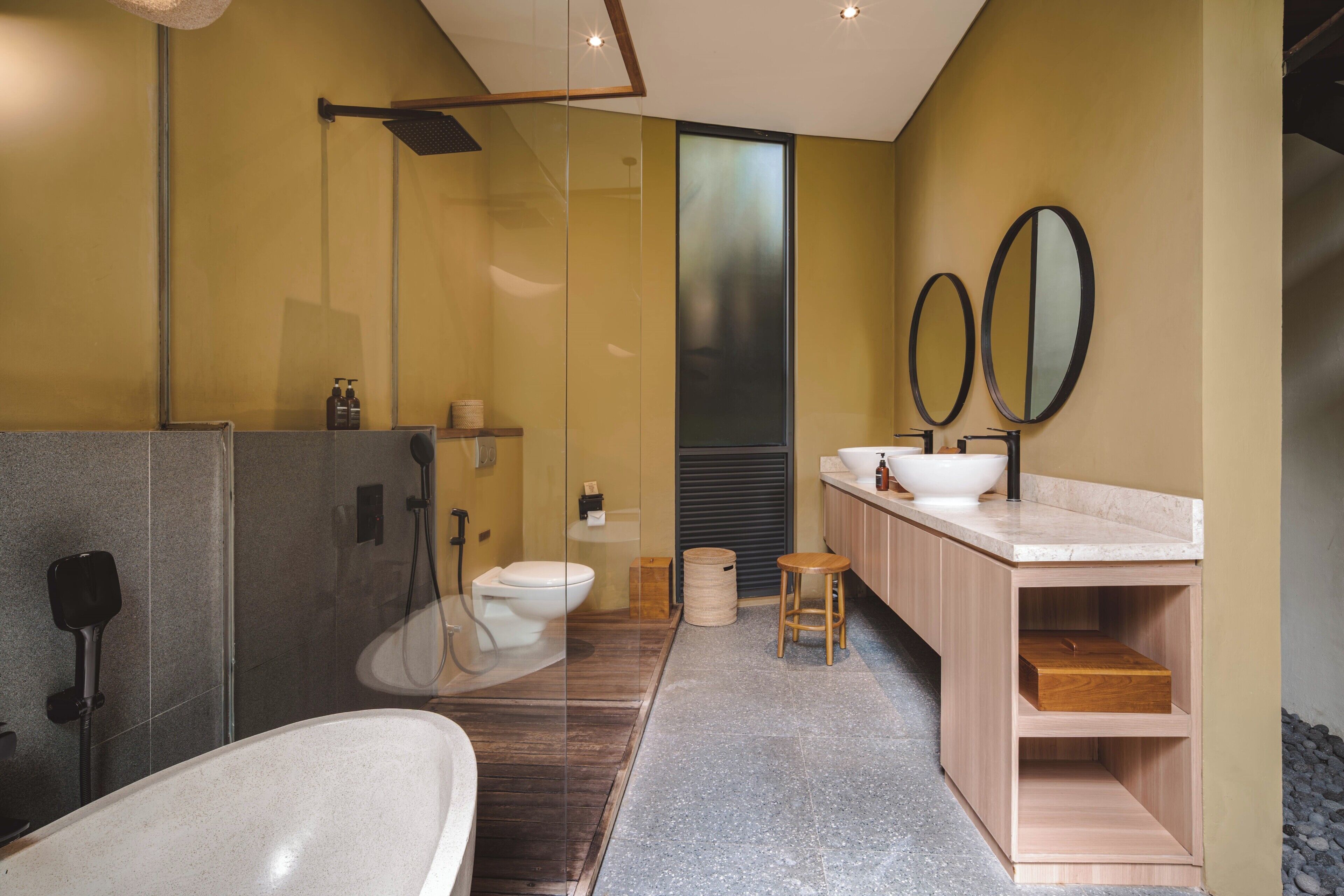 Un bagno moderno con cabina doccia in vetro, una vasca da bagno indipendente e un lavabo con doppio specchio.