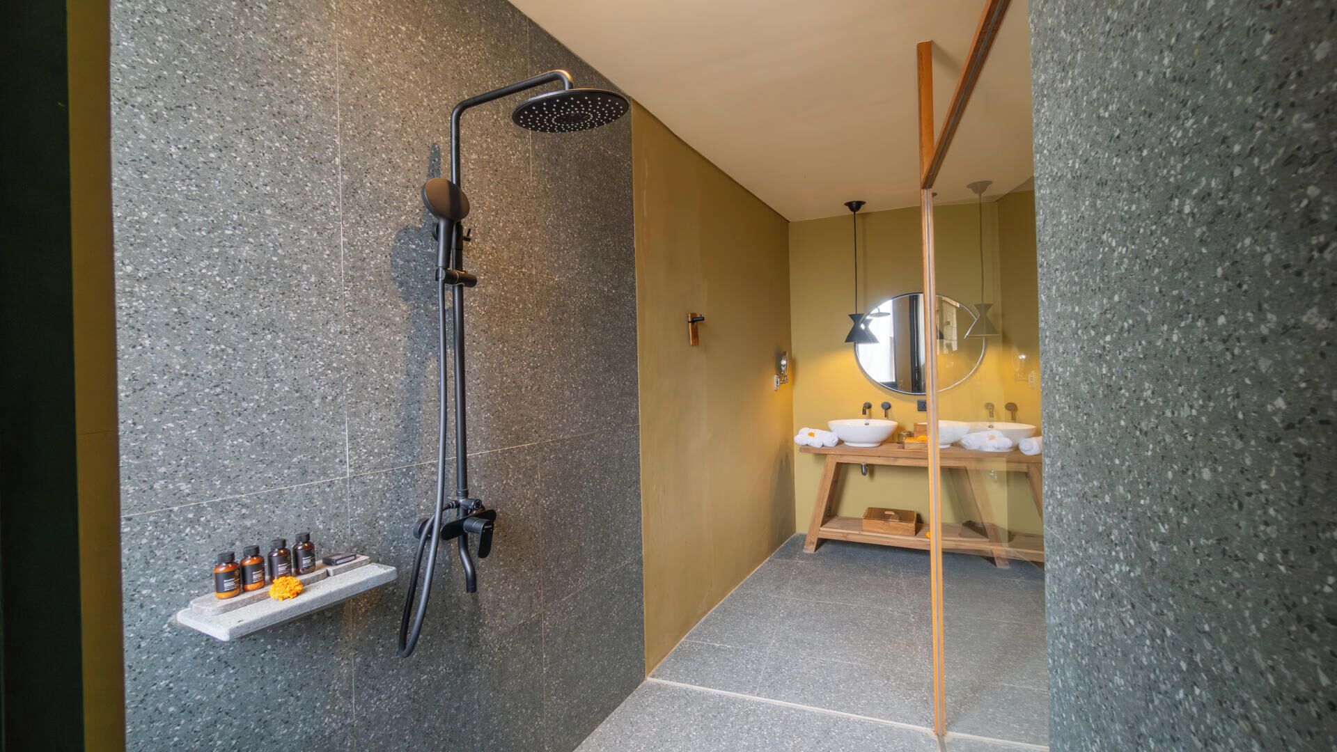 Un baño moderno con ducha, tocador doble y espejo.