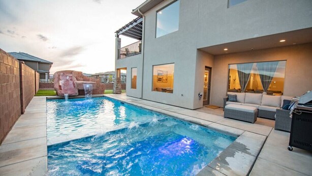 A modern house with a swimming pool, outdoor seating, and a waterfall feature. - Spacious Oasis, Private Pool, Spa & Putting Green (Hurricane)
