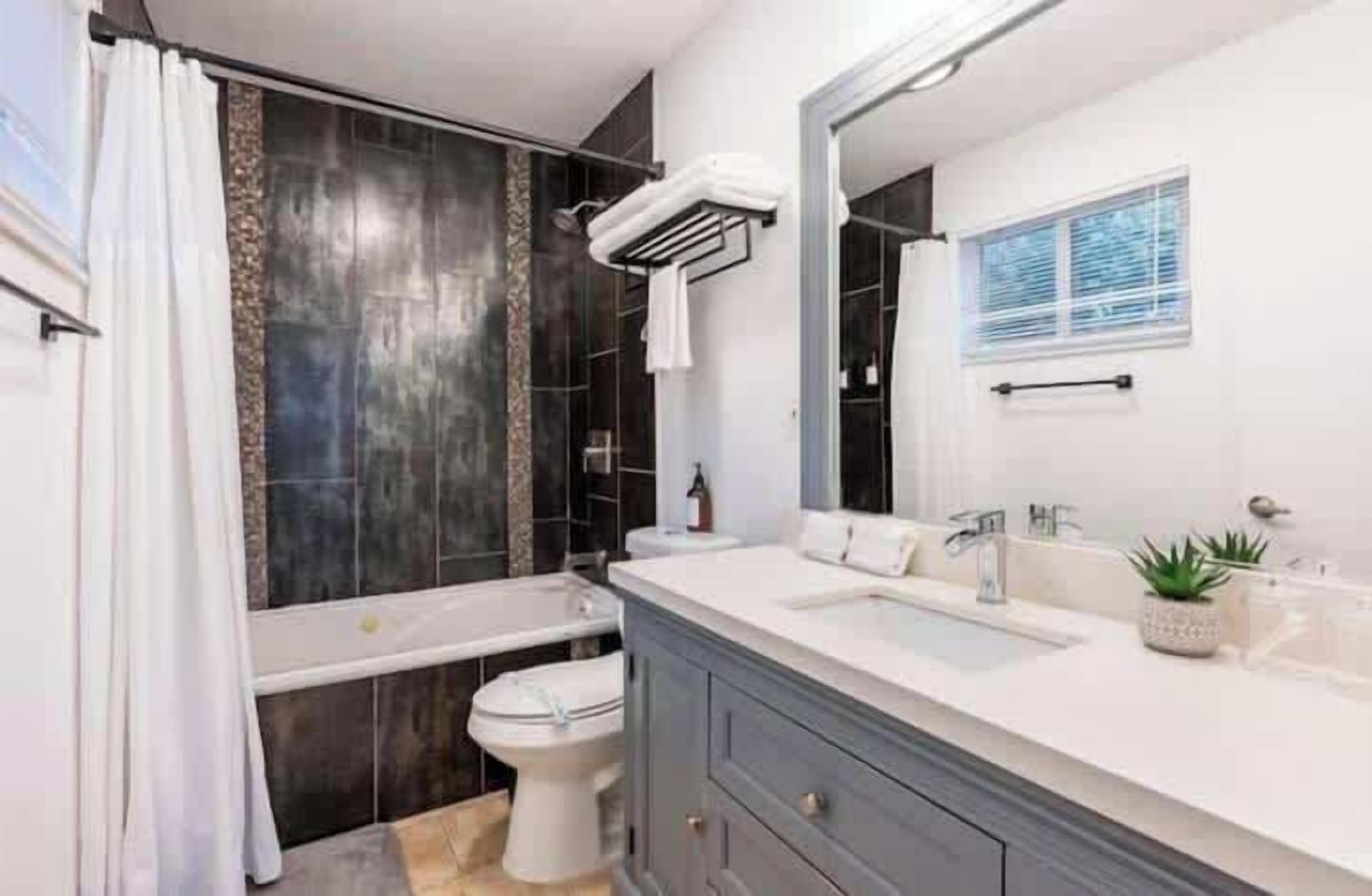 Ein modernes Badezimmer mit Badewanne, Toilette und Waschtisch.