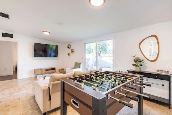 Relax in this spacious and pet-friendly living area, complete with a comfortable sofa, chic decorations, a large smart TV and a soccer table for your enjoyment.