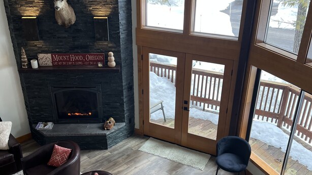 Una sala de estar acogedora con chimenea, ventanas amplias y asientos cómodos.