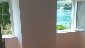 A bedroom with a bed, a window, and a chair. - Getaway Seaside Sweet (Zaton)