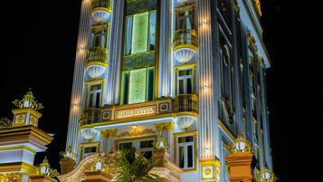 Exterior del Hotel Villa King, con detalles arquitectónicos ornamentales y señalización iluminada.