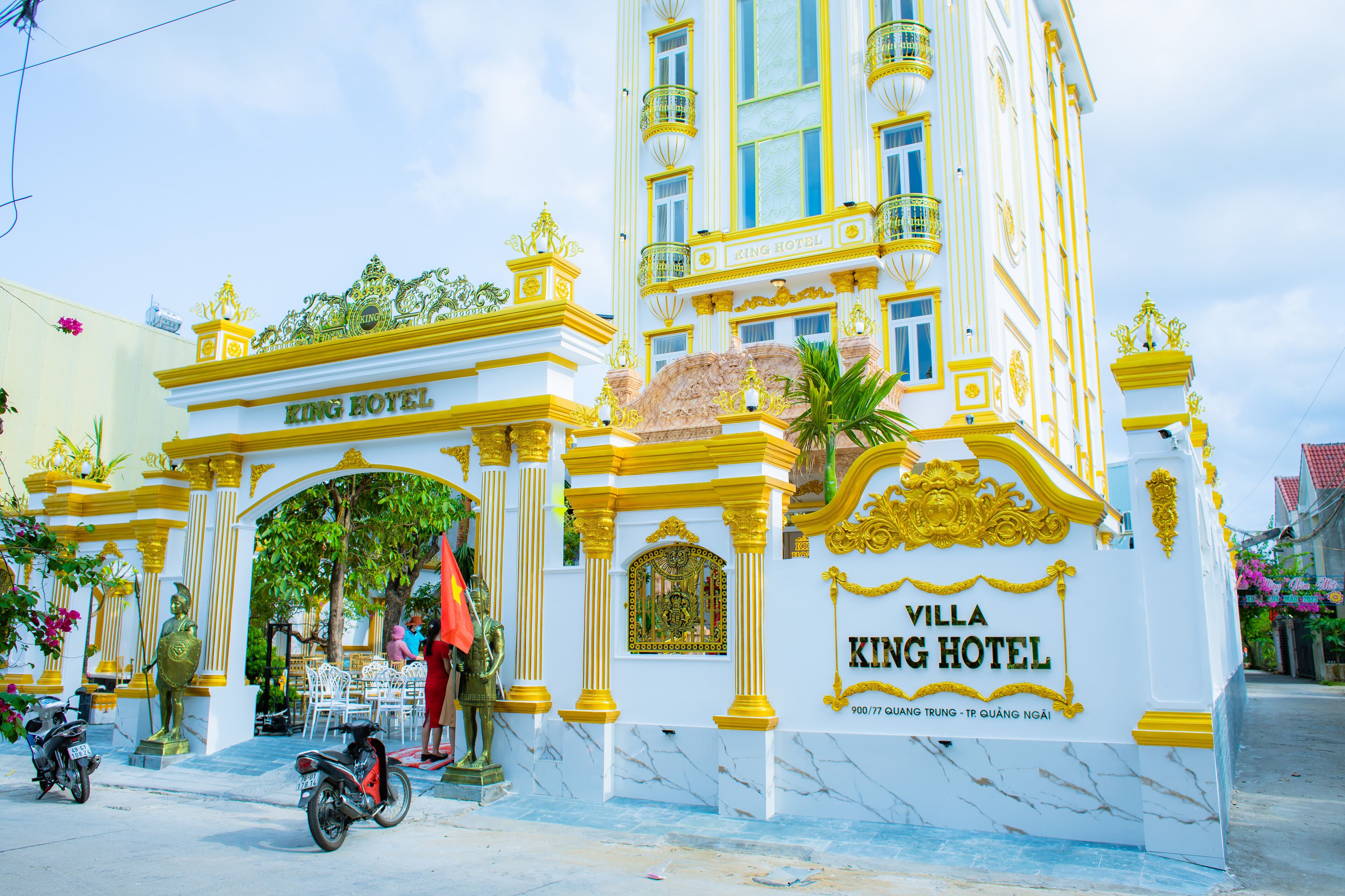 Indgangen til Villa King Hotel med en markant buegang og et skilt, der angiver hotellets navn.