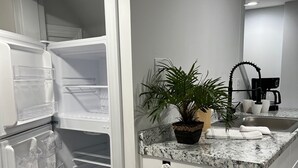 A kitchen with a white refrigerator, a sink, a coffee maker, and a potted plant. - 1st Floor Condo: Min to Nook, Amish Ctry, Hershey, Lancaster City: PetFriendly (Lancaster)