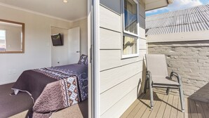 Un dormitorio con una cama, una silla y una ventana.
