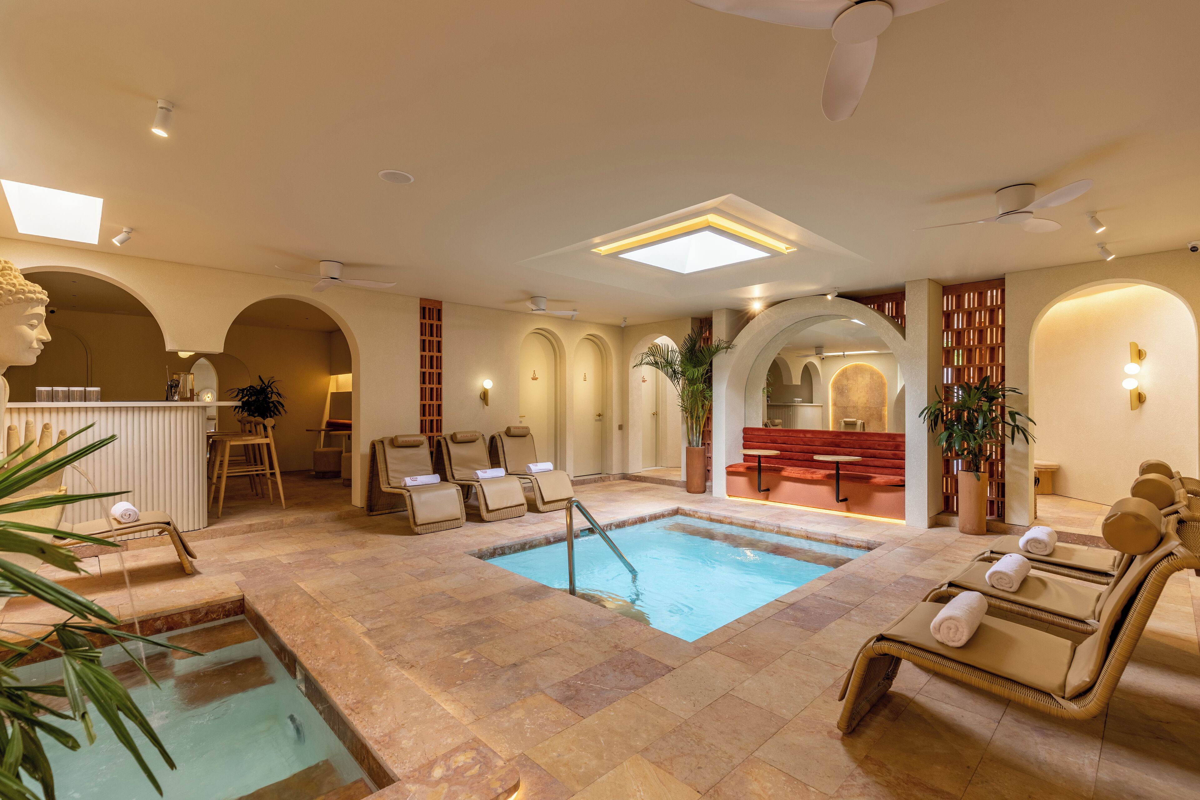A spa area with a pool, lounge chairs, and a reception desk.