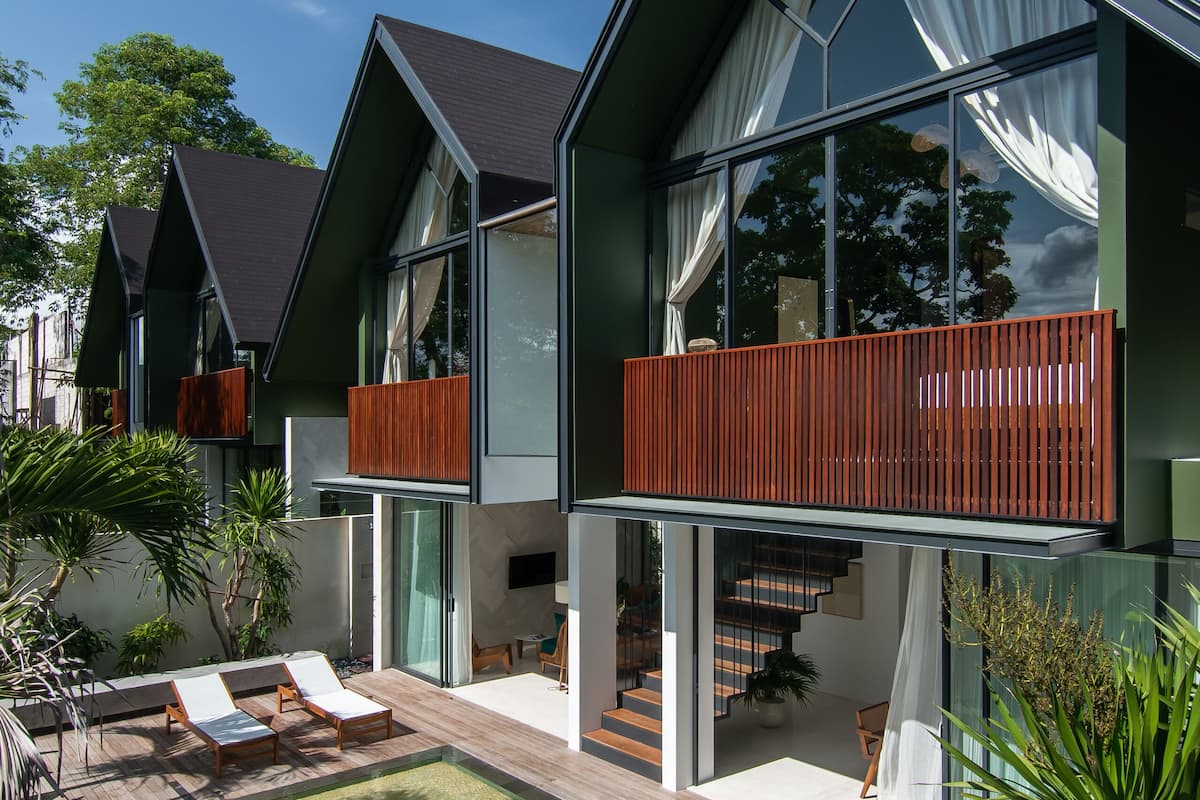 A modern house with a swimming pool, large windows, and a balcony.