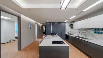 Una cocina moderna con una isla central, electrodomésticos integrados y vista al área de estar.