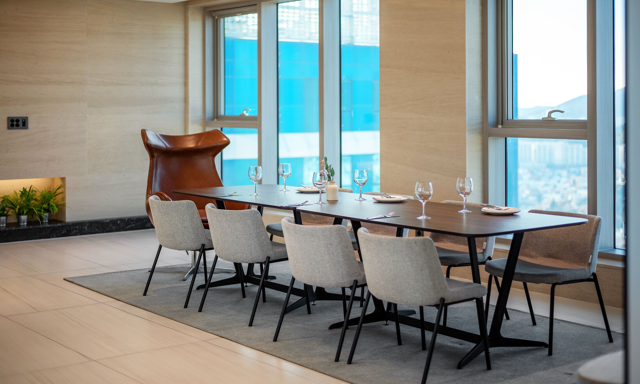 Een moderne eetruimte met een lange tafel, zes stoelen en een bijzondere sculpturale stoel.