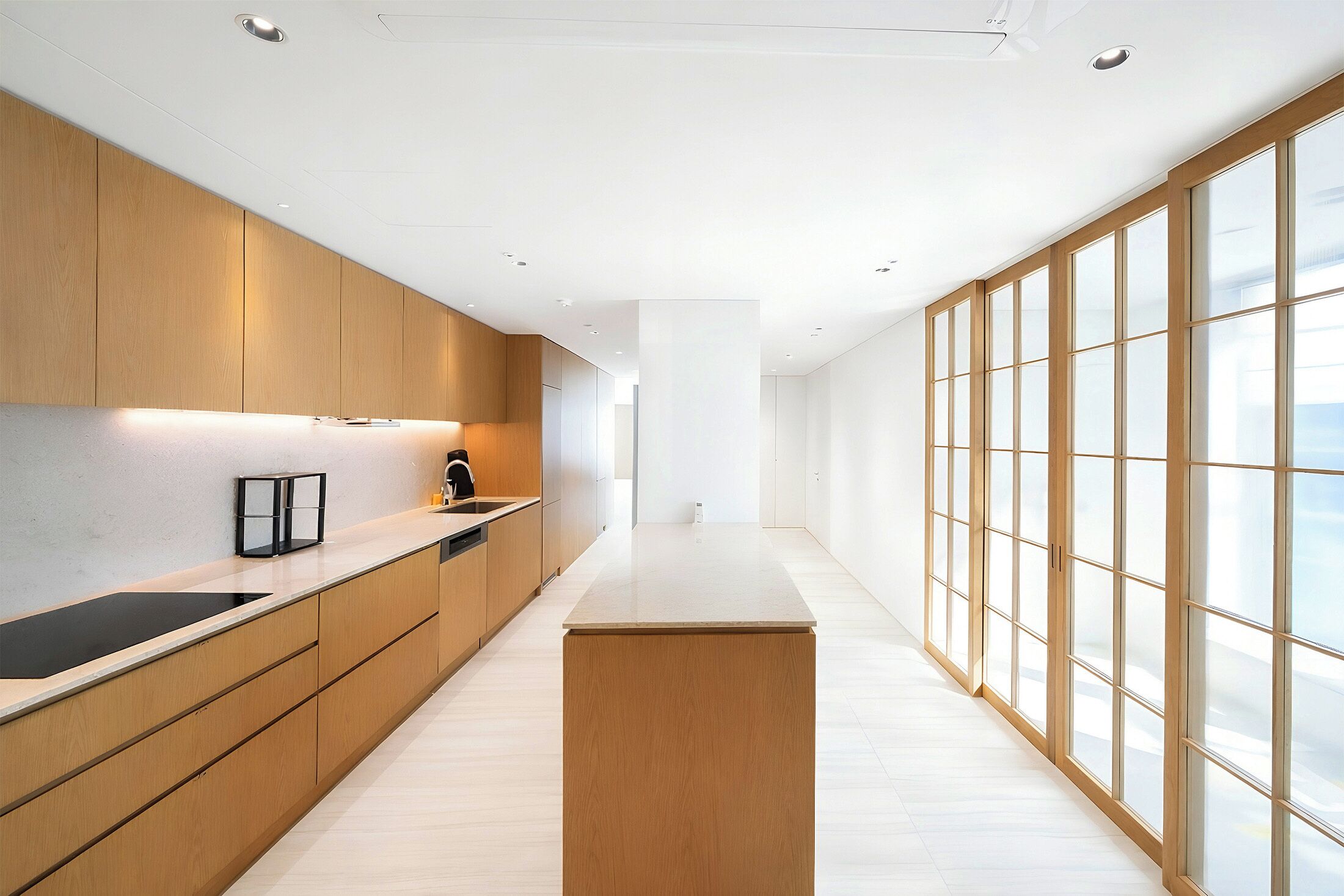 A modern kitchen with wooden cabinets, a black countertop, and a large window.