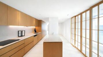 A modern kitchen with wooden cabinets, a black countertop, and a large window.