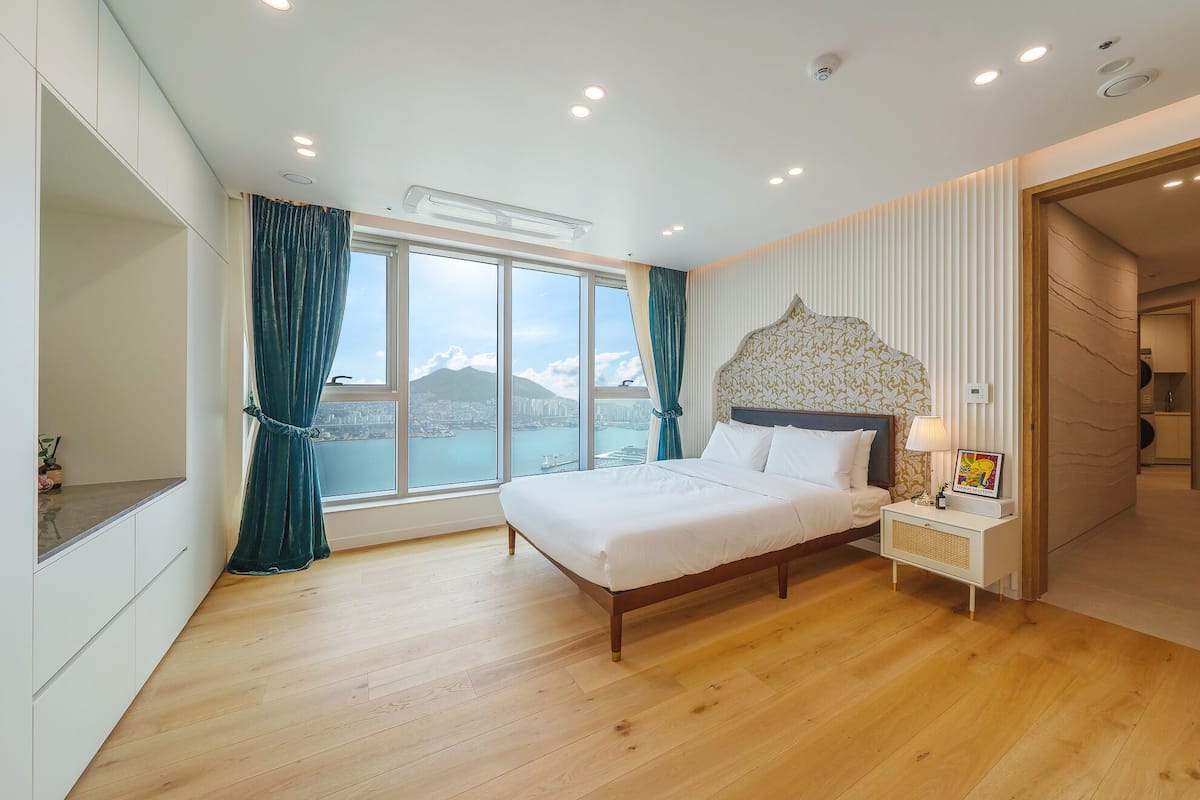 Quarto moderno com uma cama grande, vista para a cidade e um closet espaçoso.