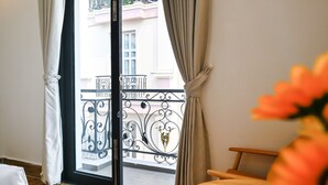 Una habitación con vistas a un balcón, una cama y una silla.