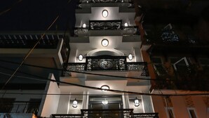 Entrada de hotel con un letrero que dice "My Hotel" y una señal de neón arriba.
