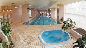 An indoor swimming pool with a separate hot tub area, tiled walls, and potted plants. - Beijing Jiuxian Apartment (Beijing)