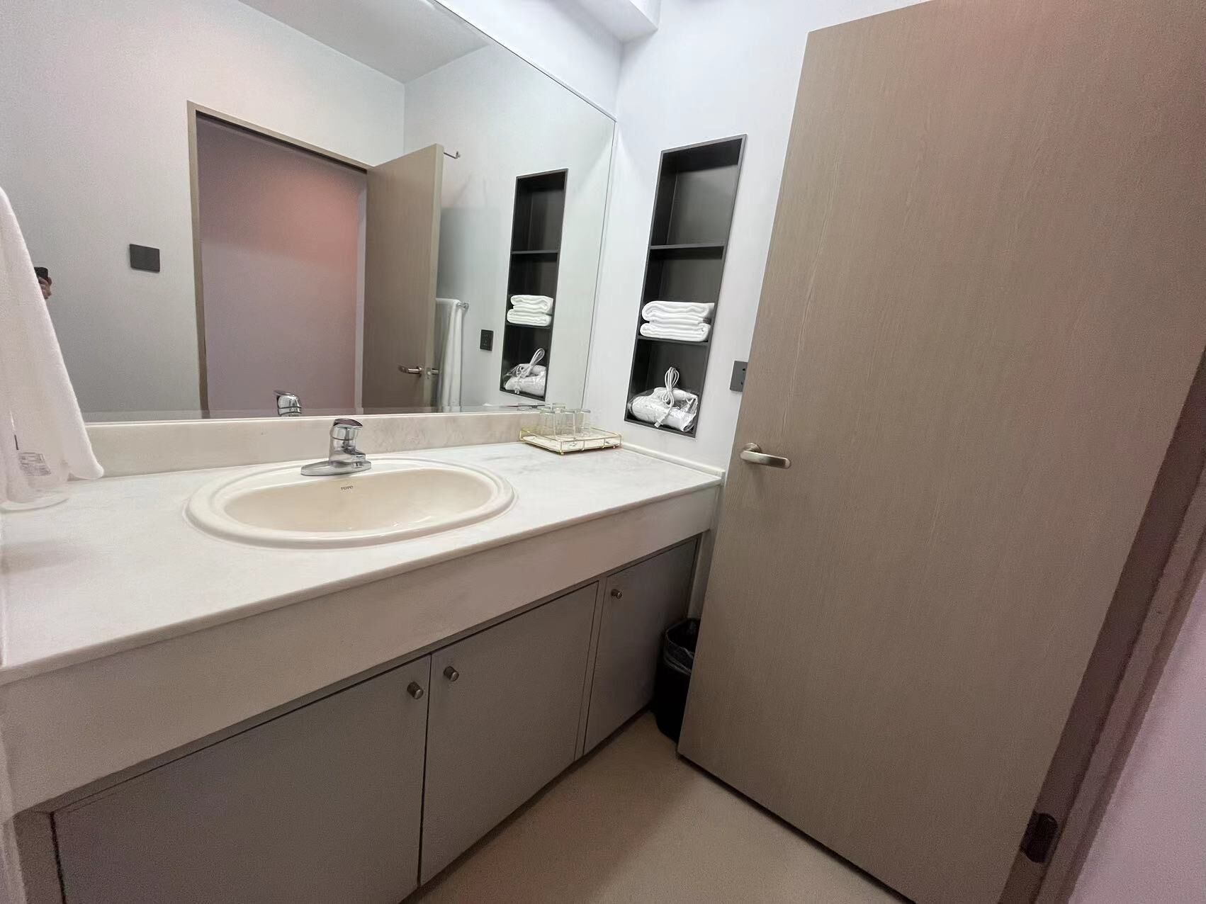 A bathroom with a white sink, a mirror, and a towel rack.