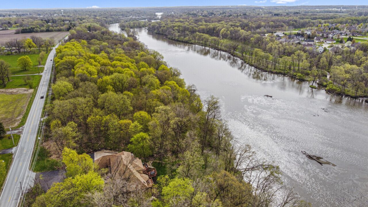 Un río con un puente, rodeado de vegetación y zonas residenciales.