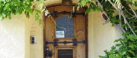 Una puerta de madera con un letrero que dice 'GASTHEM' y una pequeña ventana encima.