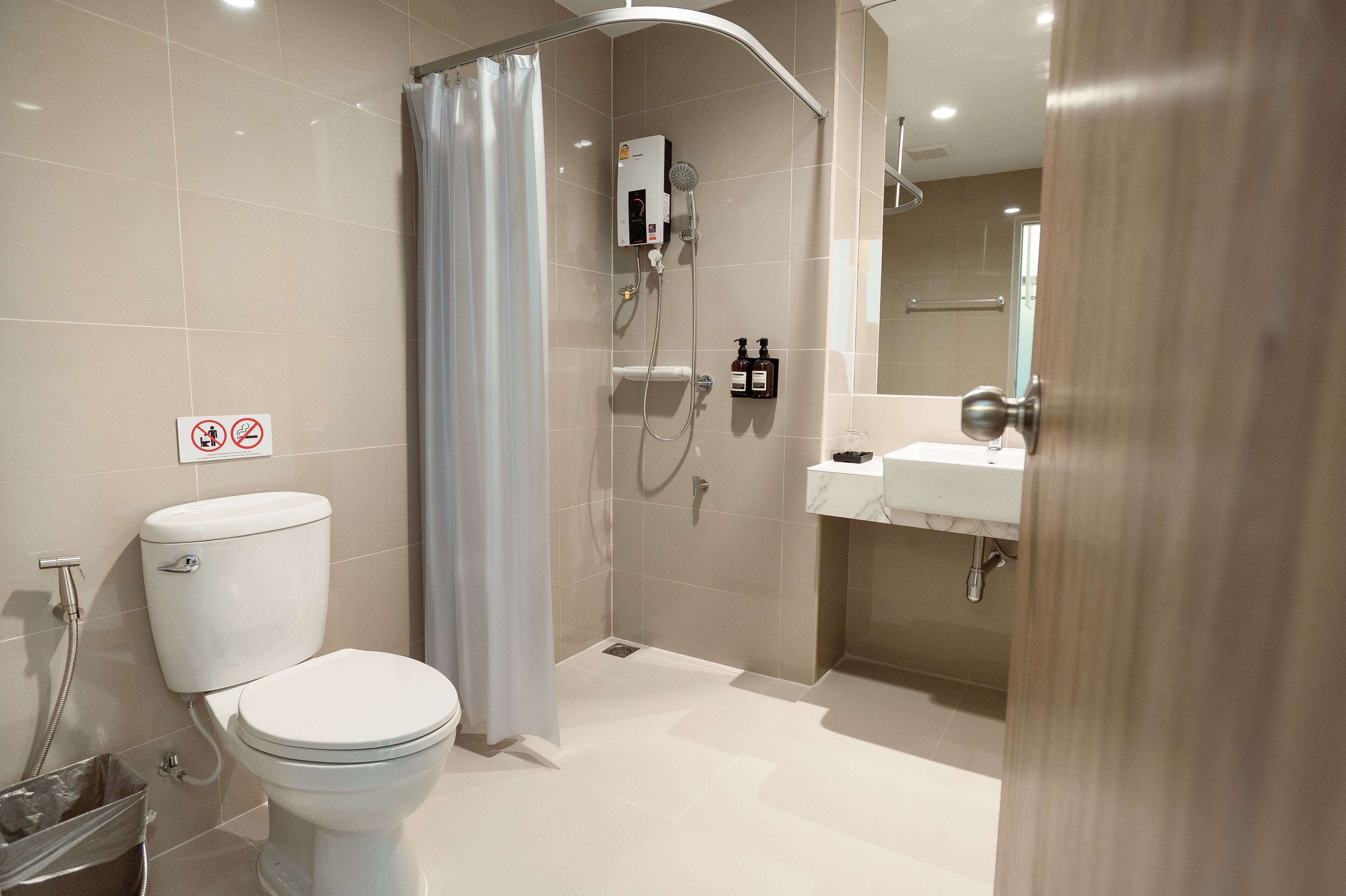 Un baño moderno con inodoro, ducha y lavamanos.