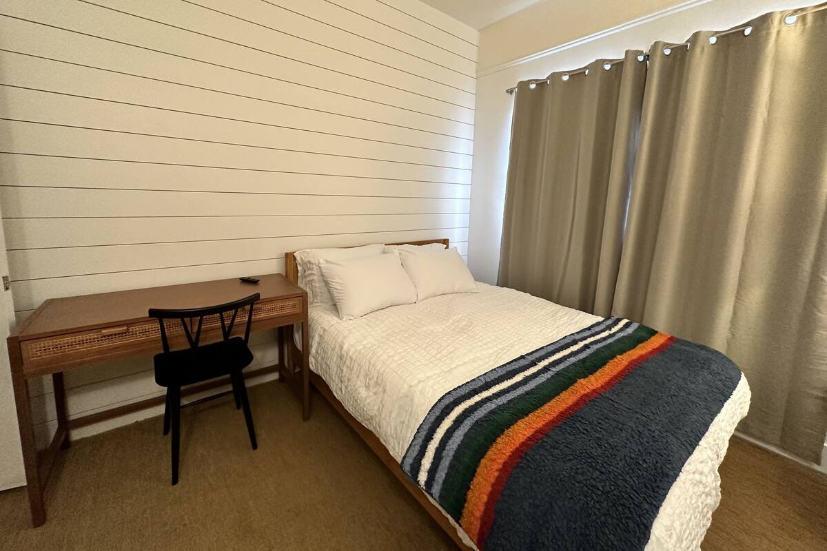 Ein Schlafzimmer mit einem Bett, einem Schreibtisch und einem Stuhl.