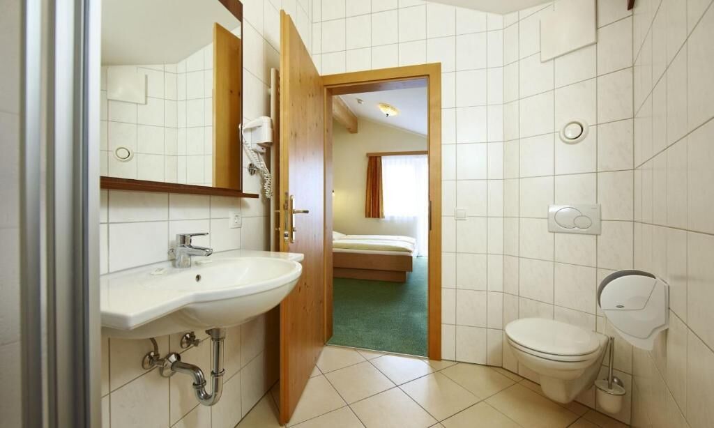 A bathroom with a sink, toilet, and a shower area.