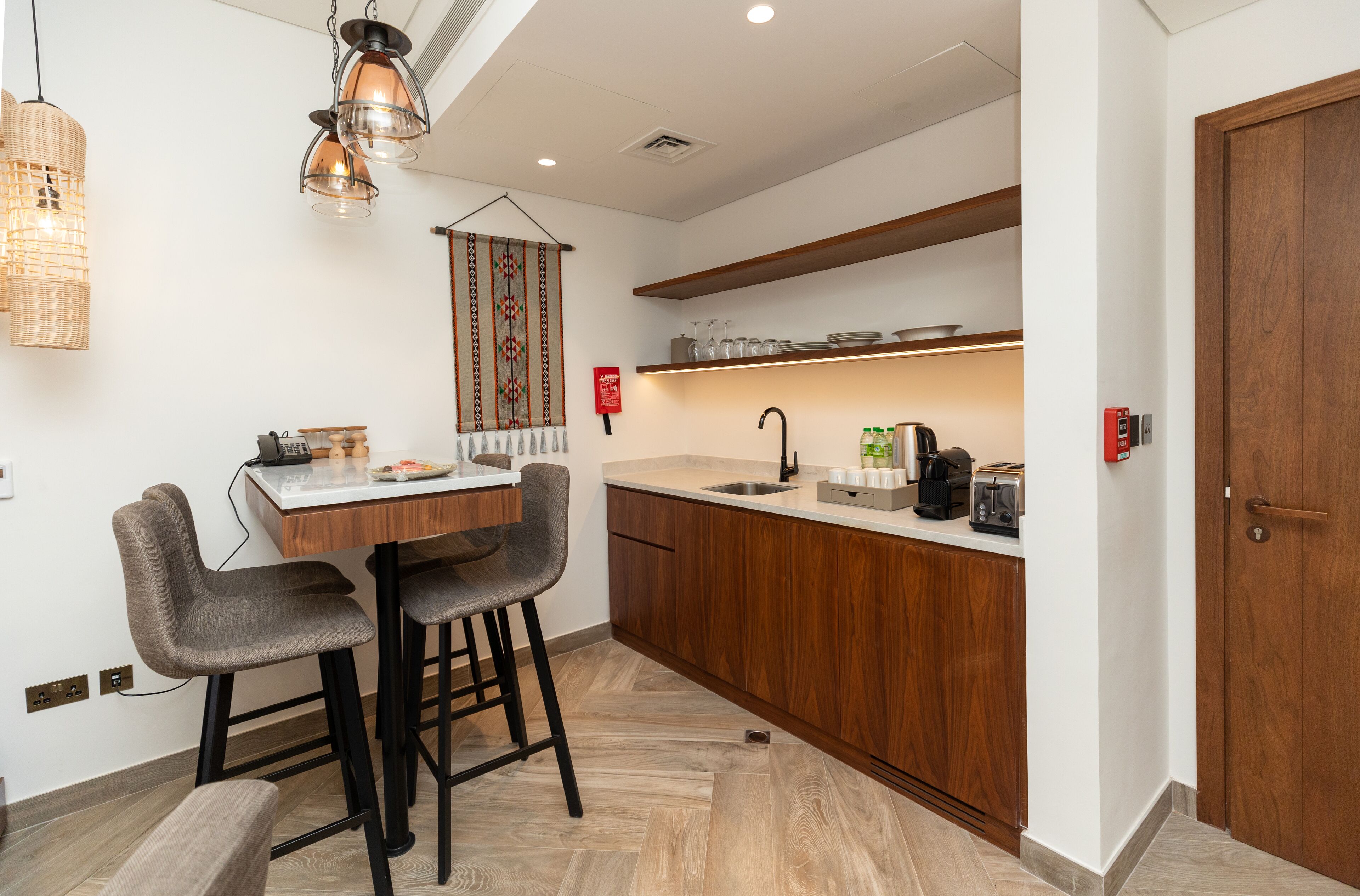 A modern kitchen with wooden cabinets, a built-in sink, and a dining area with bar stools.