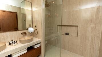 A modern bathroom with two sinks, a glass-enclosed shower, and a wooden vanity.